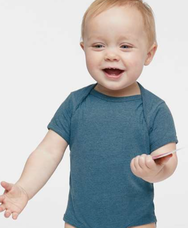 a baby in a blue shirt holding a toothbrush