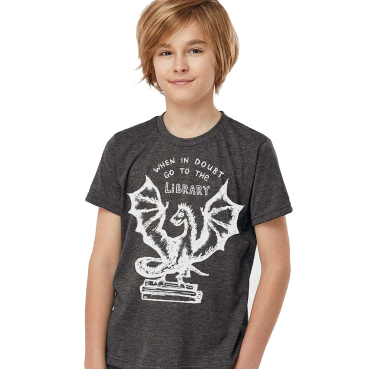 a young boy wearing a t - shirt with a dragon on it