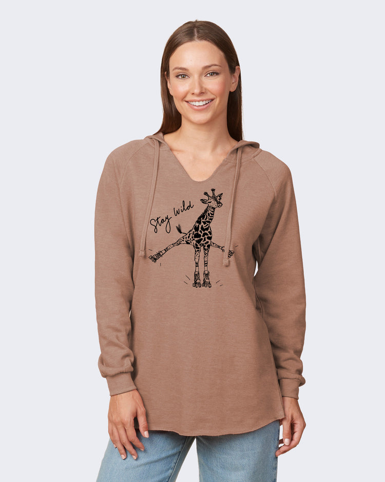 A woman wearing a brown hooded sweatshirt with a graphic of a giraffe and the text "Stay wild" printed on it.