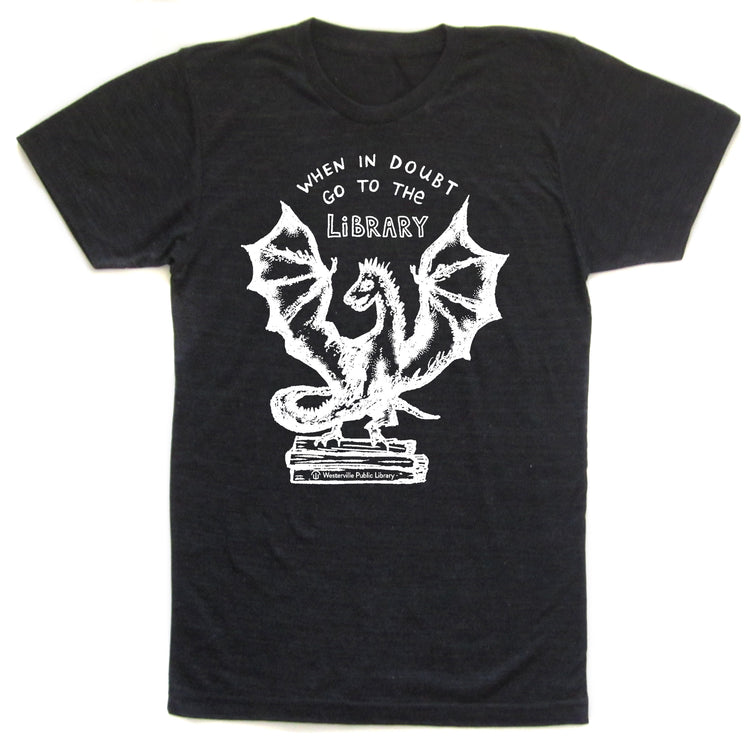 A black t-shirt with a white graphic design depicting a dragon and the text "WHEN IN DOUBT GO TO THE LIBRARY" printed on it.
