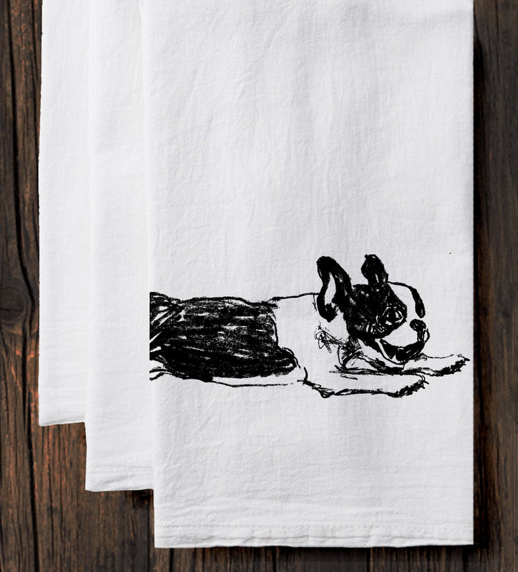 A white towel with a black line drawing of a dog on it.