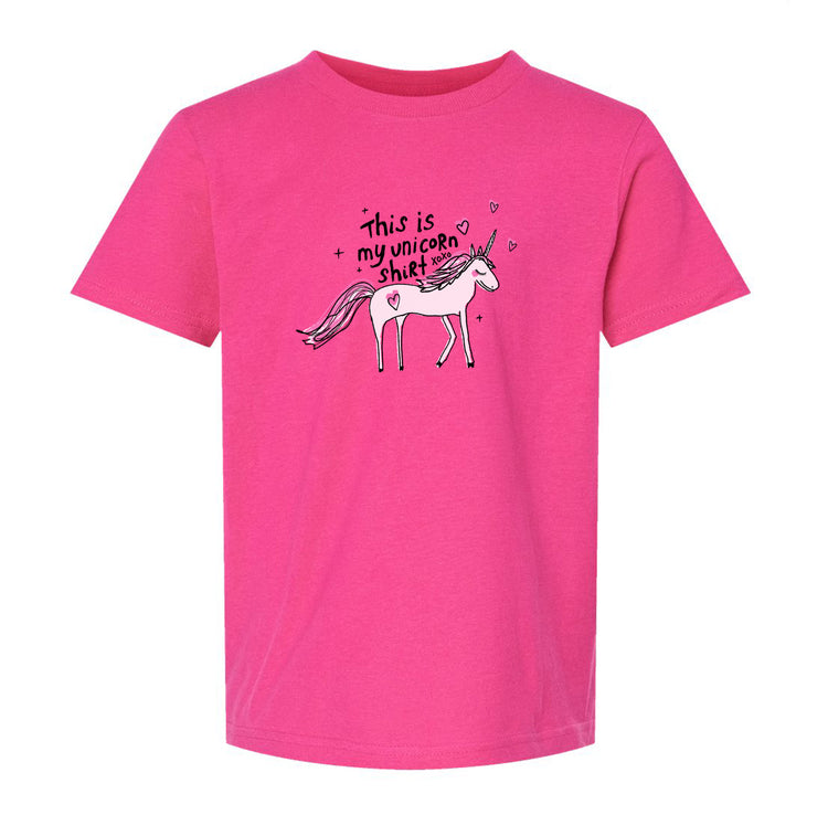 A pink t-shirt with a graphic of a unicorn and the text "This is my unicorn shirt" printed on it.
