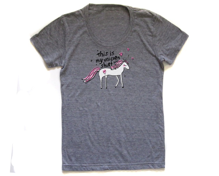 The image is a gray t-shirt with a graphic design of a white unicorn and pink hearts.