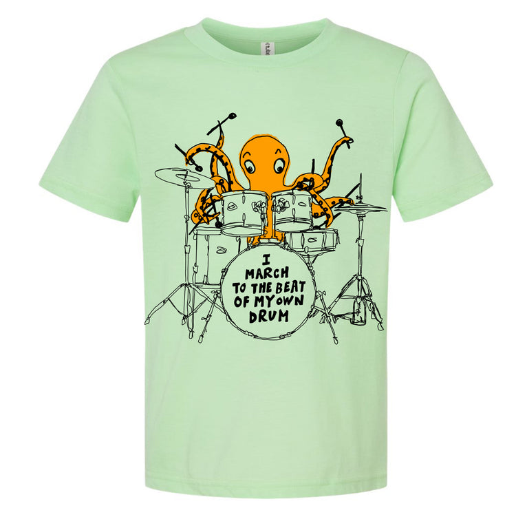 An orange octopus is playing a drum set, with the text "I MARCH TO THE BEAT OF MY OWN DRUM" displayed on the t-shirt.