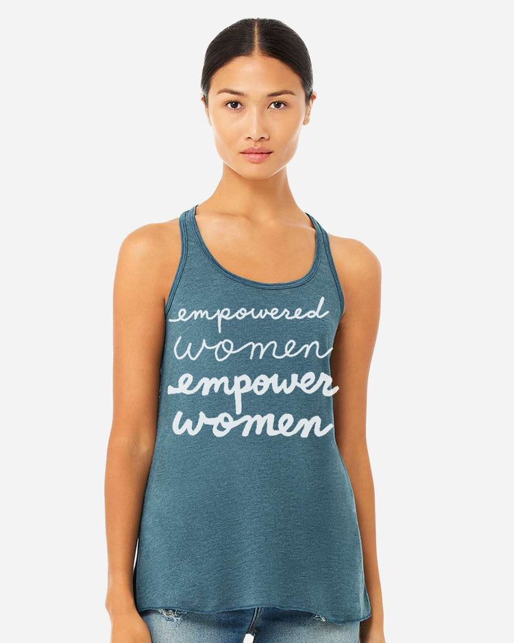 A woman wearing a teal tank top with the text "empowered women empower women" printed on it.