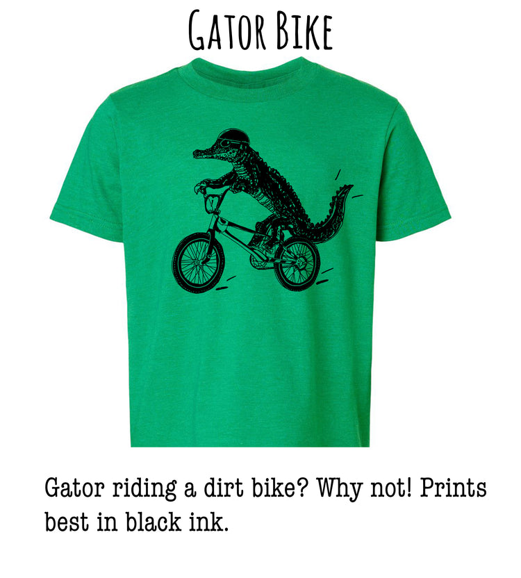 A green t-shirt with a graphic of a gator riding a dirt bike printed on it.