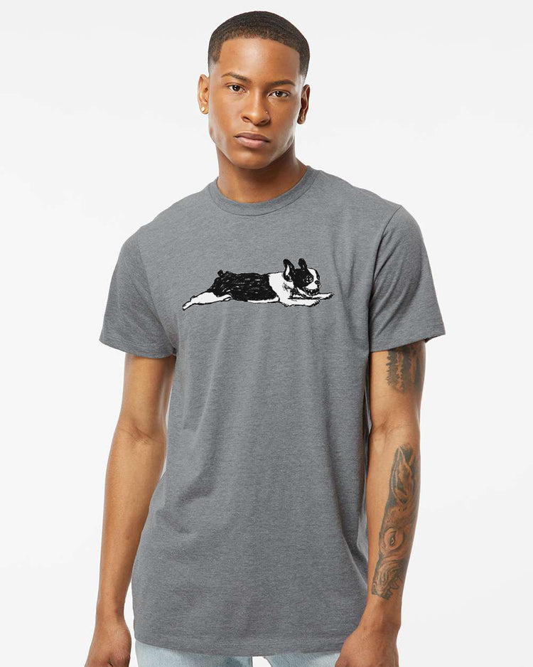 A young man wearing a gray t-shirt with a graphic of a dog lying down.