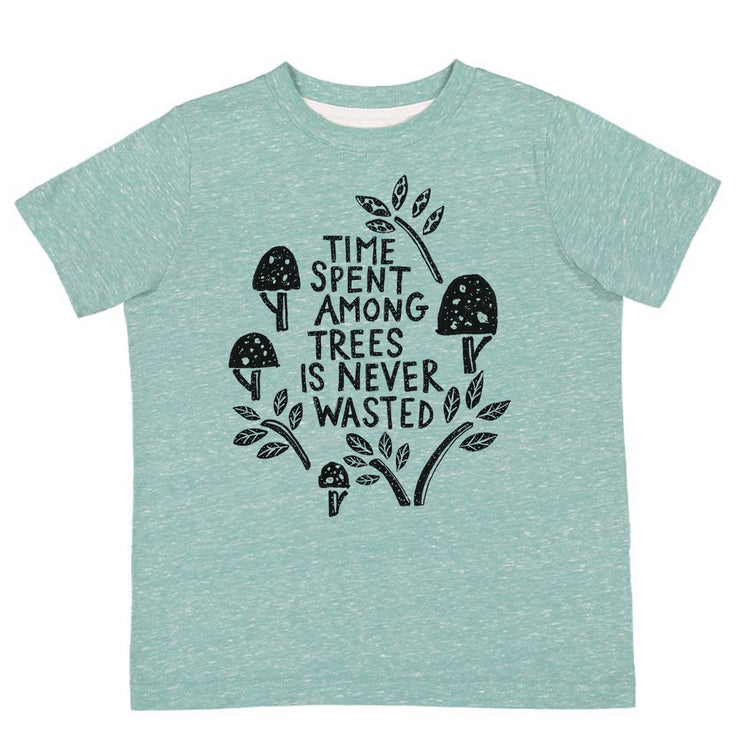 A light green t-shirt with a graphic design featuring a tree with mushrooms and leaves, along with the text "Time spent among trees is never wasted".