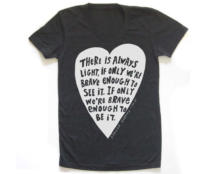 The image is a black t-shirt with a white heart-shaped graphic containing a quote in a black font.