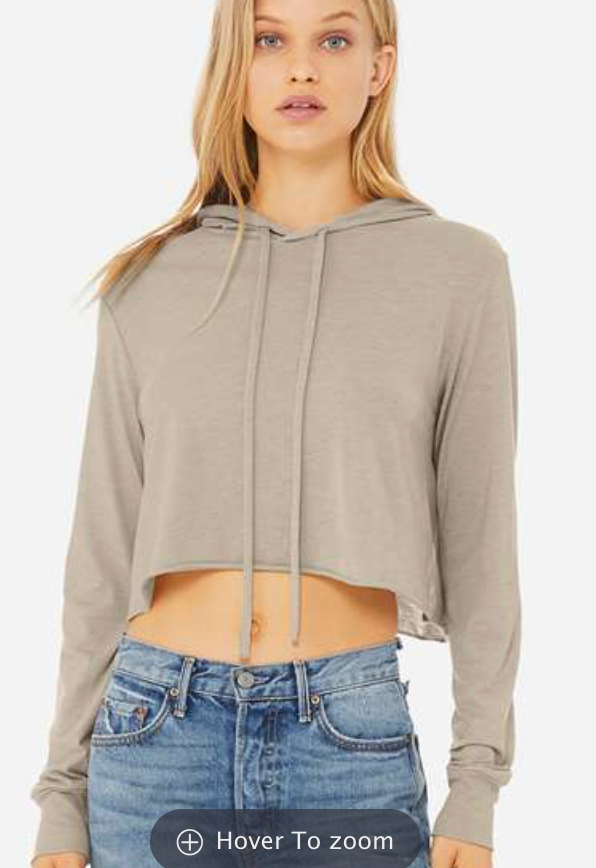 A young woman with long blonde hair wearing a gray hoodie and blue jeans.