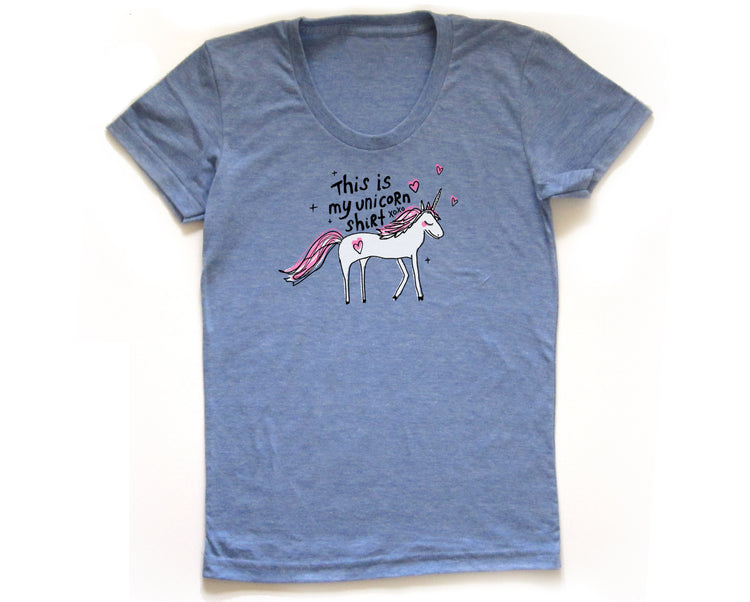 A blue t-shirt with a graphic of a white unicorn and the text "This is my unicorn shirt" printed on it.