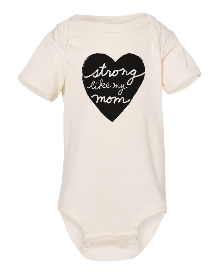 A cream-colored baby onesie with a black heart-shaped graphic and the text "Strong like my mom" printed on it.