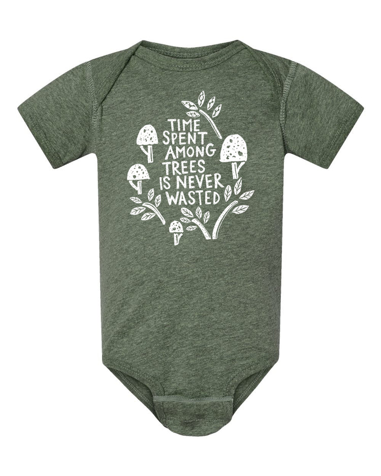 A green baby onesie with a white graphic design on it. The design features a tree with mushrooms and leaves, along with the text "Time spent among trees is never wasted".