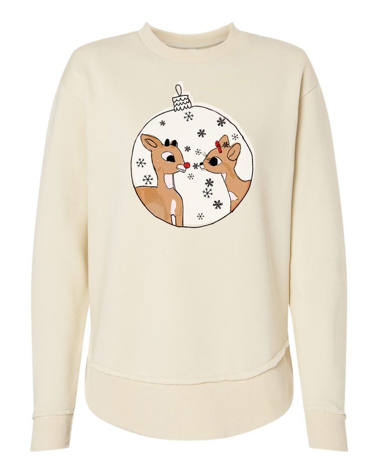 A cream-colored sweater with a circular graphic design featuring two cartoon reindeer, one with a red bow, surrounded by snowflakes.