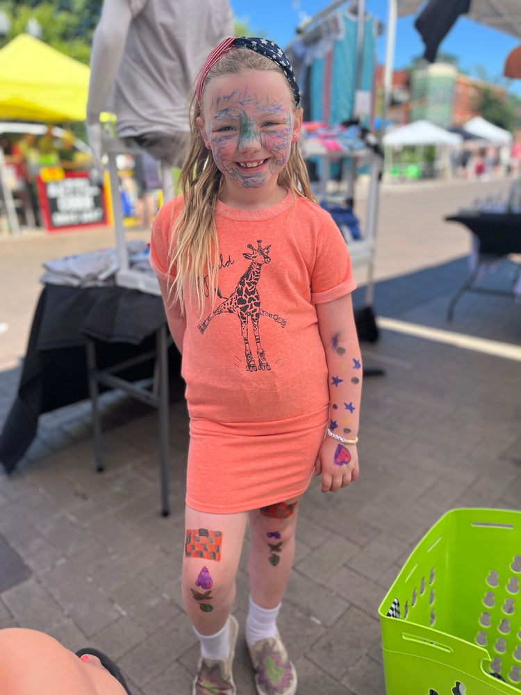 a little girl with face paint and a giraffe on her body