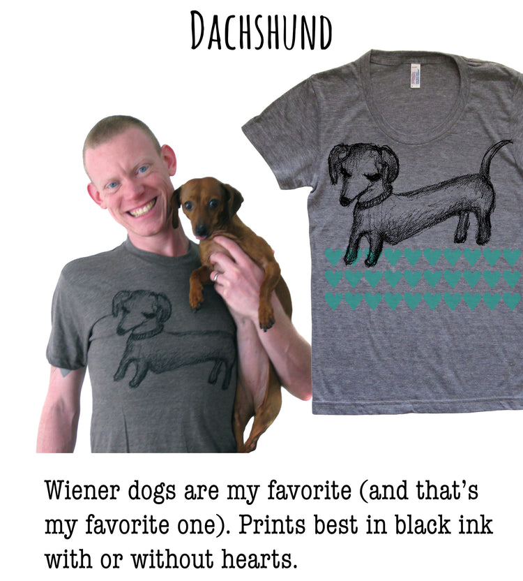 A man is holding a small brown dog in his arms, both smiling, with a gray t-shirt featuring a black and green dog design on the right side of the image.