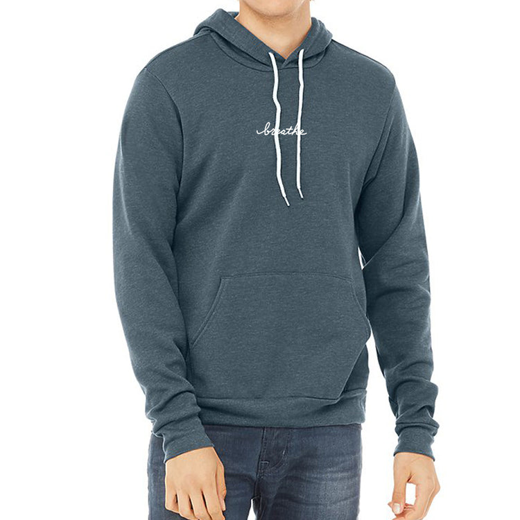 A man wearing a gray hoodie with the word "breath" printed on it.