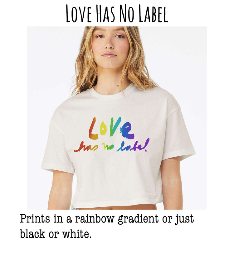 A young woman wearing a white t-shirt with a rainbow gradient design and the text "Love Has No Label" printed on it.