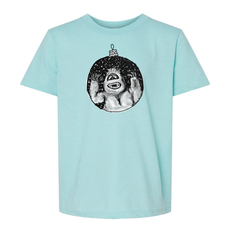 A light blue t-shirt with a graphic design depicting a monster or monster-like creature inside a circular ornament.
