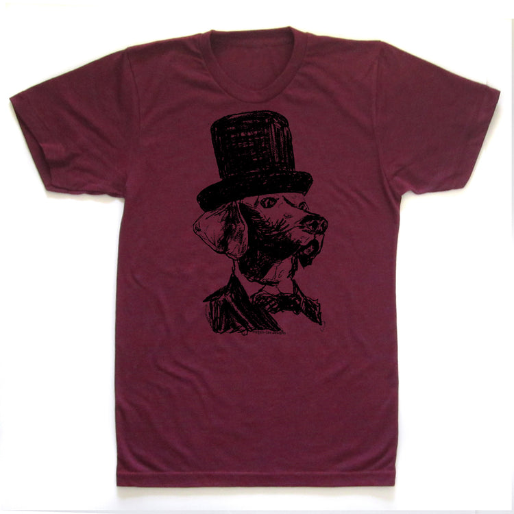 A burgundy-colored t-shirt with a black and white illustration of a dog wearing a top hat.
