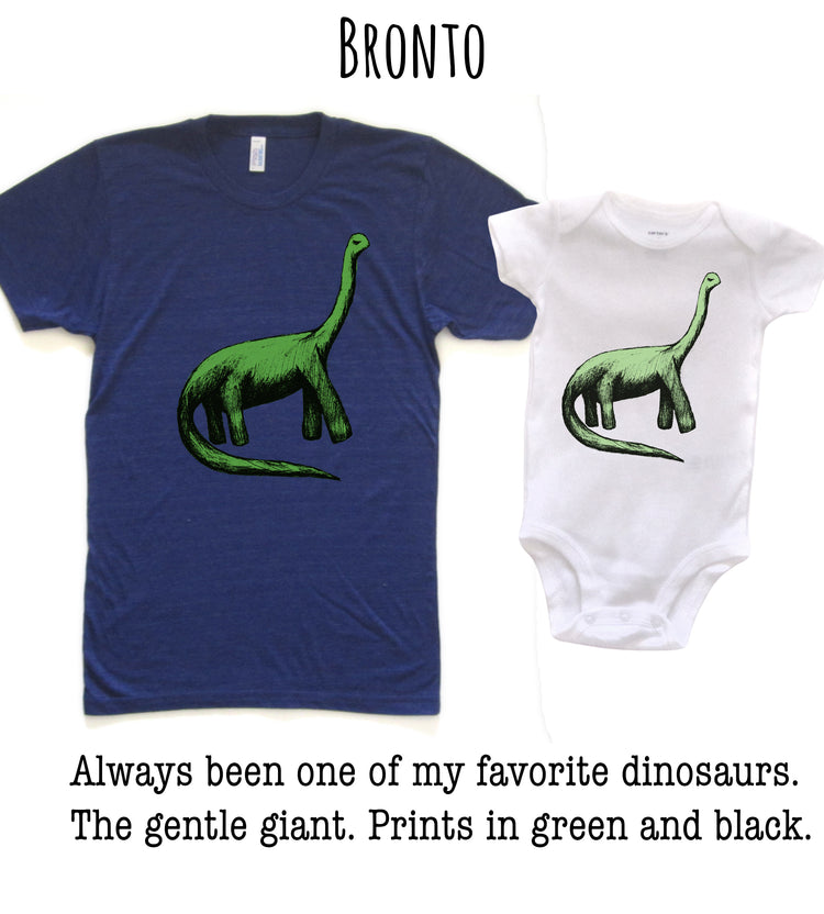 two t-shirts with a dinosaur design, one larger and one smaller, both in shades of green and black.
