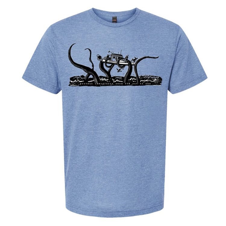 A blue t-shirt with a graphic design depicting a large octopus or squid-like creature with a boat or ship on top of it, surrounded by waves.