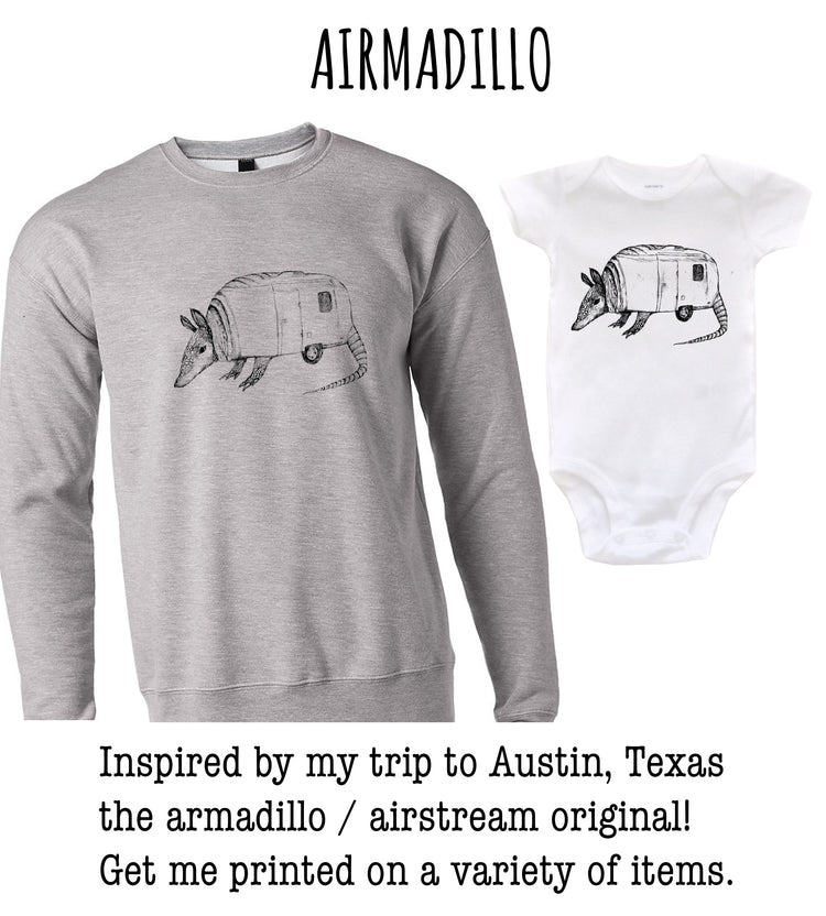 A gray sweatshirt with a black and white illustration of an armadillo and a white baby onesie with the same armadillo illustration.