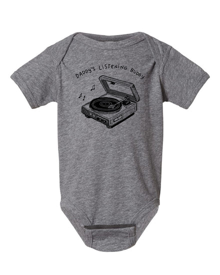 A gray baby onesie with a graphic design of a record player and the text "DADDA'S LISTENING BUDDY" printed on it.