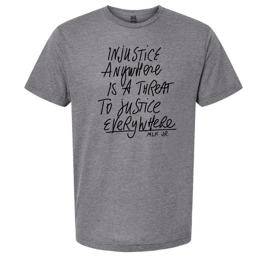 a gray t-shirt with a printed message that reads "Injustice anywhere is a threat to justice everywhere" and the name "MLK Jr." below it.