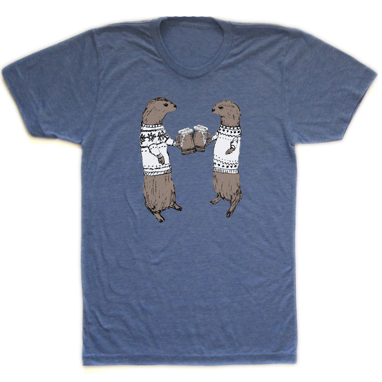 A blue t-shirt with a graphic design depicting two otters wearing sweaters and holding beer glasses, appearing to be enjoying a casual social gathering.