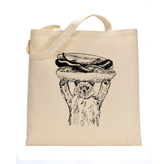 A beige tote bag with a black and white illustration of a bear holding a hot dog on its head.