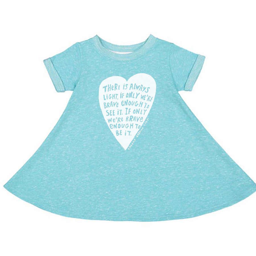 A light blue dress with a white heart-shaped graphic on the front, featuring a motivational quote about being brave and having light.