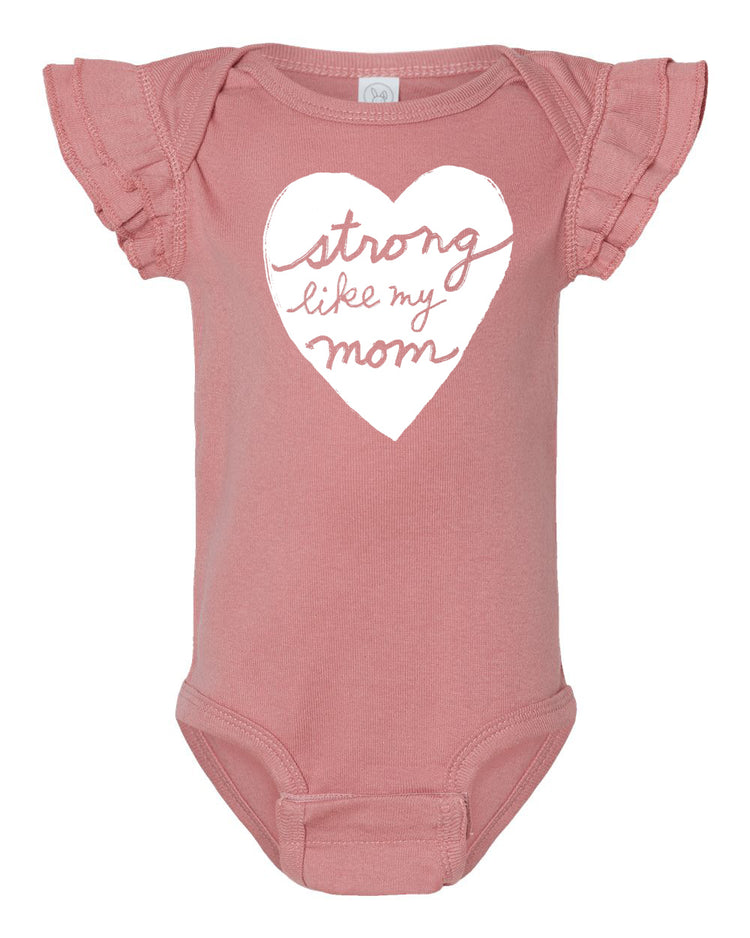 A pink baby onesie with a heart-shaped design and the text "Strong like my mom" printed on it.