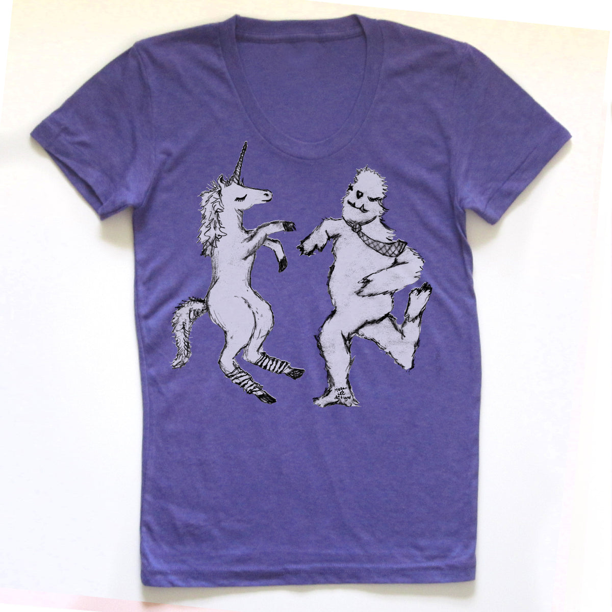 A purple t-shirt with a graphic design depicting a unicorn and a creature resembling a bear or similar animal.