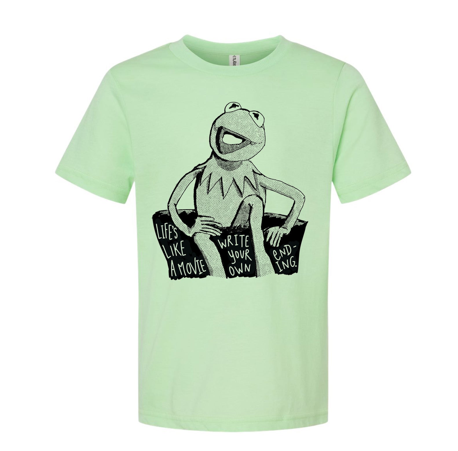 A light green t-shirt with a black and white illustration of Kermit the Frog sitting on a rock and the text "Lives like a movie, write your own ending" printed on it.
