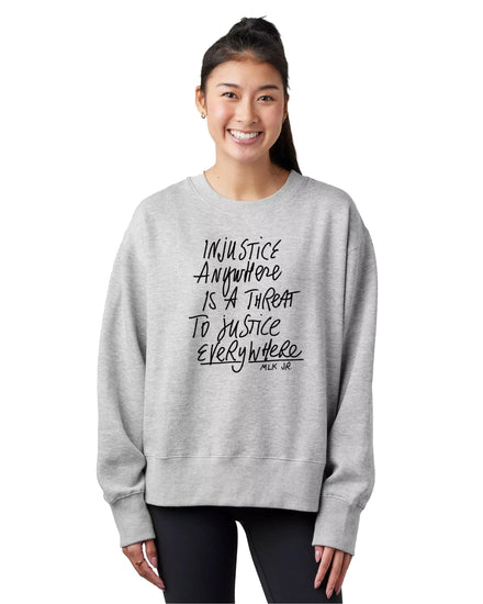 A woman wearing a gray sweatshirt with a printed message about justice.
