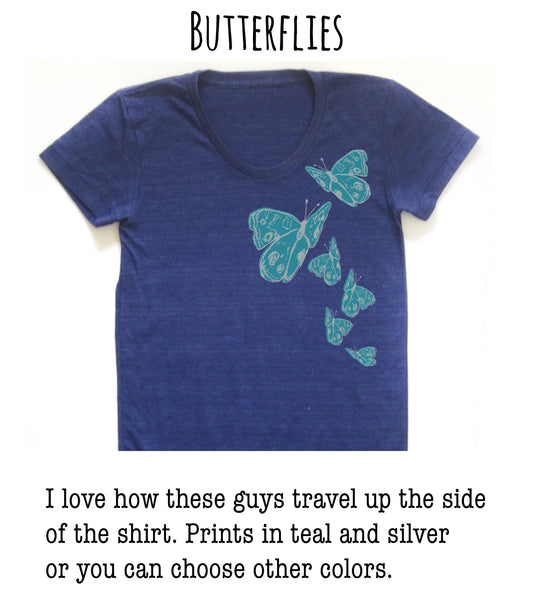 A blue t-shirt with a design of butterflies printed on it.