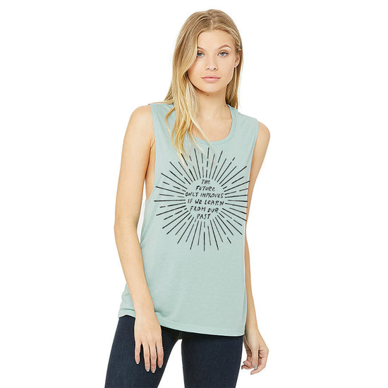 A woman wearing a sleeveless light blue tank top with a graphic design on it.