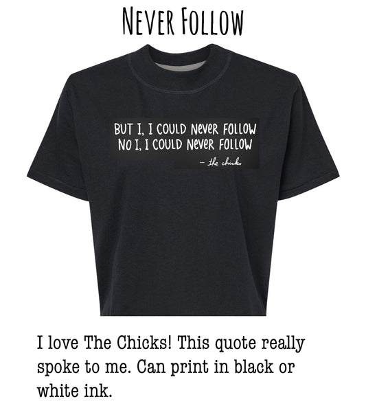 a black t-shirt with a quote printed on it, which reads: "BUT I I COULD NEVER FOLLOW NO I COULD NEVER FOLLOW - the chicks". The quote is in white text and is located on the front of the t-shirt.