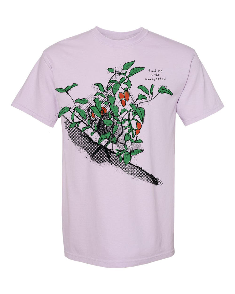 A pink t-shirt with a graphic design depicting a plant with green leaves and orange fruits.