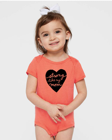 a little girl wearing a short sleeved shirt with a heart on it