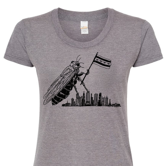 A gray t-shirt with a graphic design depicting a large insect holding a flag, with a city skyline in the background.