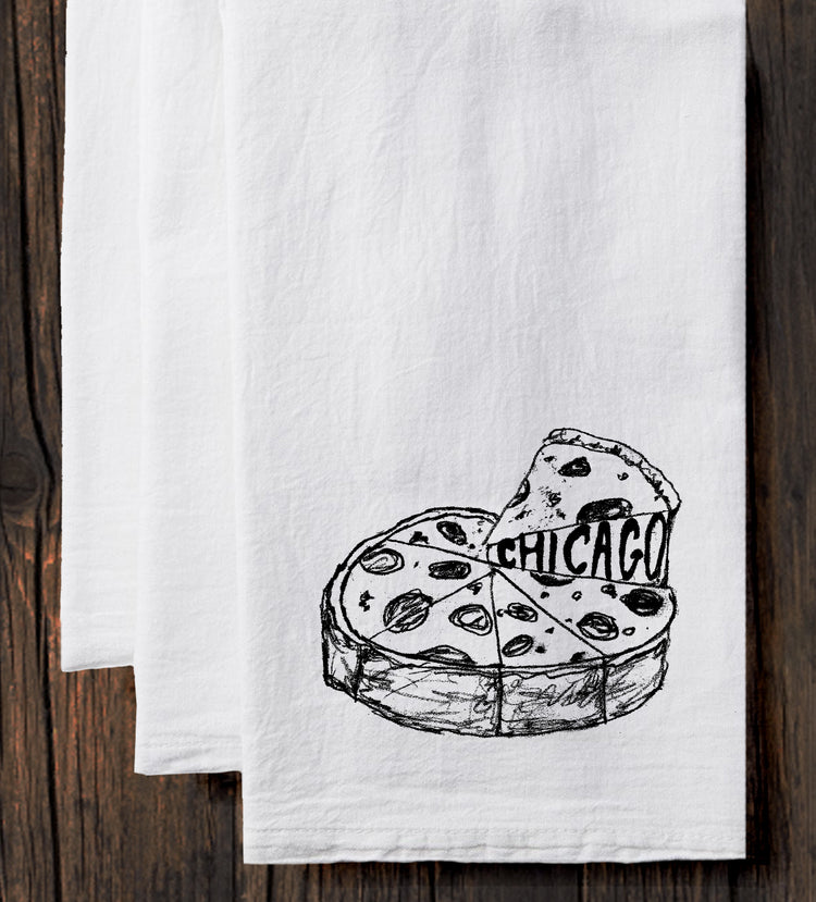 A white towel with a black and white illustration of a slice of pizza with the word "CHICAGO" written on it.