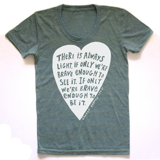 a gray t-shirt with a white heart-shaped graphic containing a quote about bravery and self-confidence.