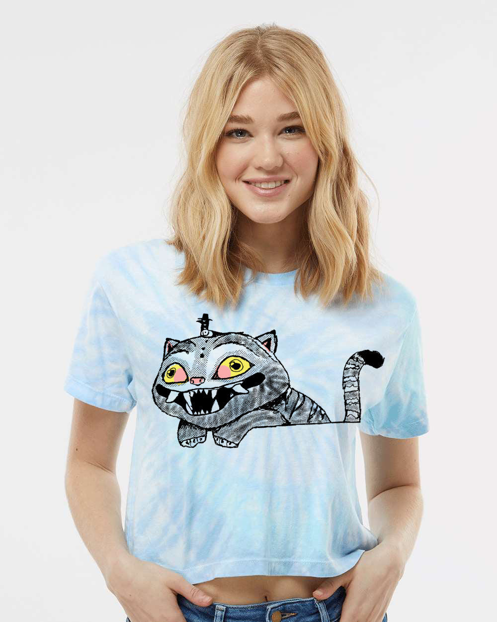 A smiling woman wearing a blue tie-dye shirt with a cartoon cat graphic.