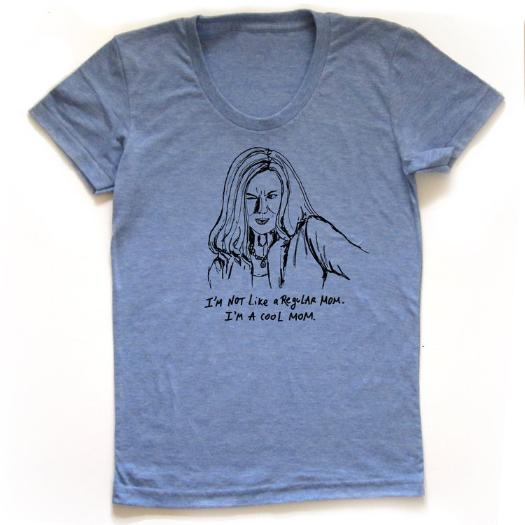 A blue t-shirt with a black and white illustration of a woman's face and the text "I'M NOT LIKE A REGULAR MOM. I'M A COOL MOM."