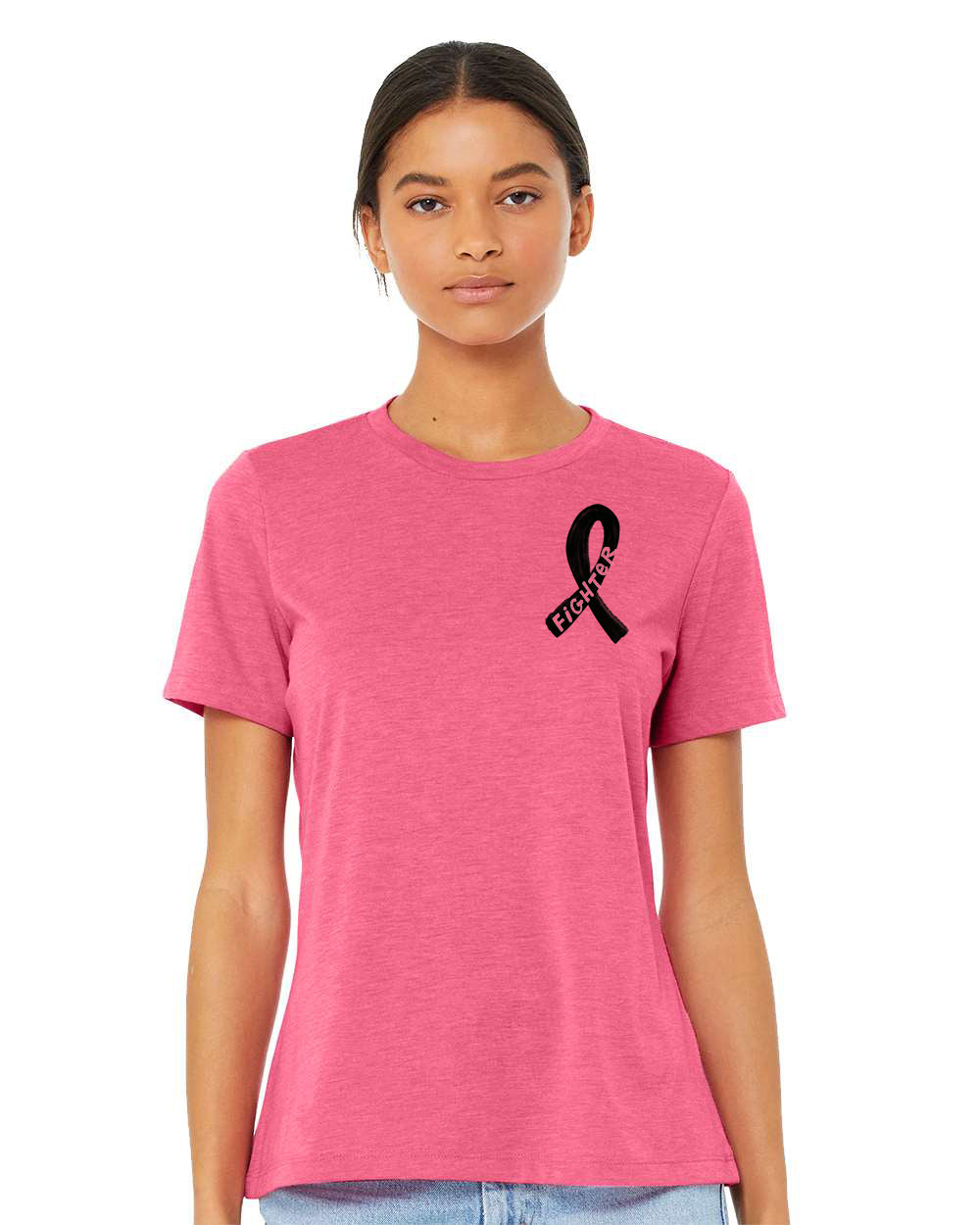 A woman wearing a pink t-shirt with a black ribbon symbol on it, standing against a white background.