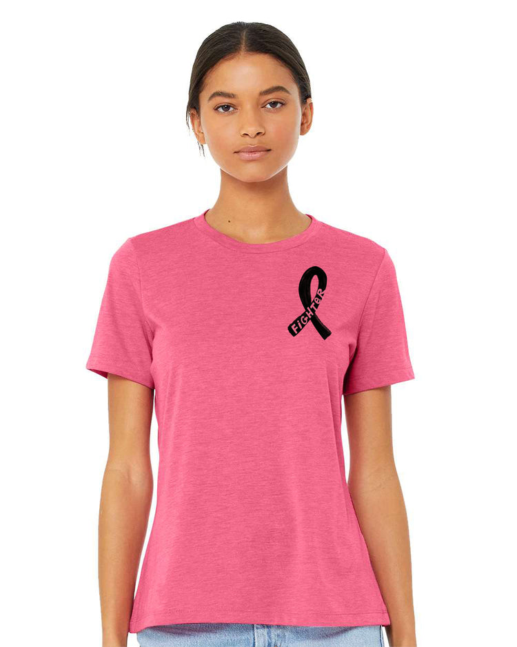 A woman wearing a pink t-shirt with a black ribbon symbol on it, standing against a white background.
