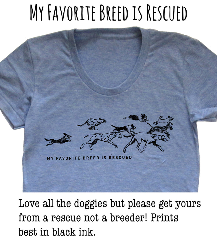 A gray t-shirt with a graphic design depicting a group of dogs running together, accompanied by the text "My favorite breed is rescued" and a message encouraging people to adopt rescue dogs instead of buying from breeders.