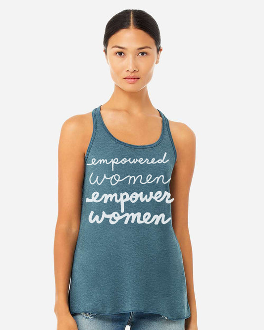 A woman wearing a teal tank top with the text "empowered women empower women" printed on it.